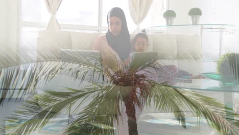 animation of asian mother in hijab sitting with daughter over landscape