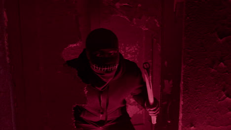 expectant man wearing black balaclava, holding an ax and hidden behind a wall in a ruined building