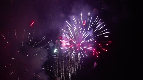 destellos brillantes de fuegos artificiales festivos en el cielo negro de la noche.