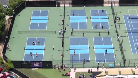 national pickleball tournament with multiple courts and people playing in games; aerial view