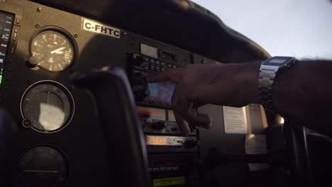 pilot inside cockpit using navigation equipment in small airplane