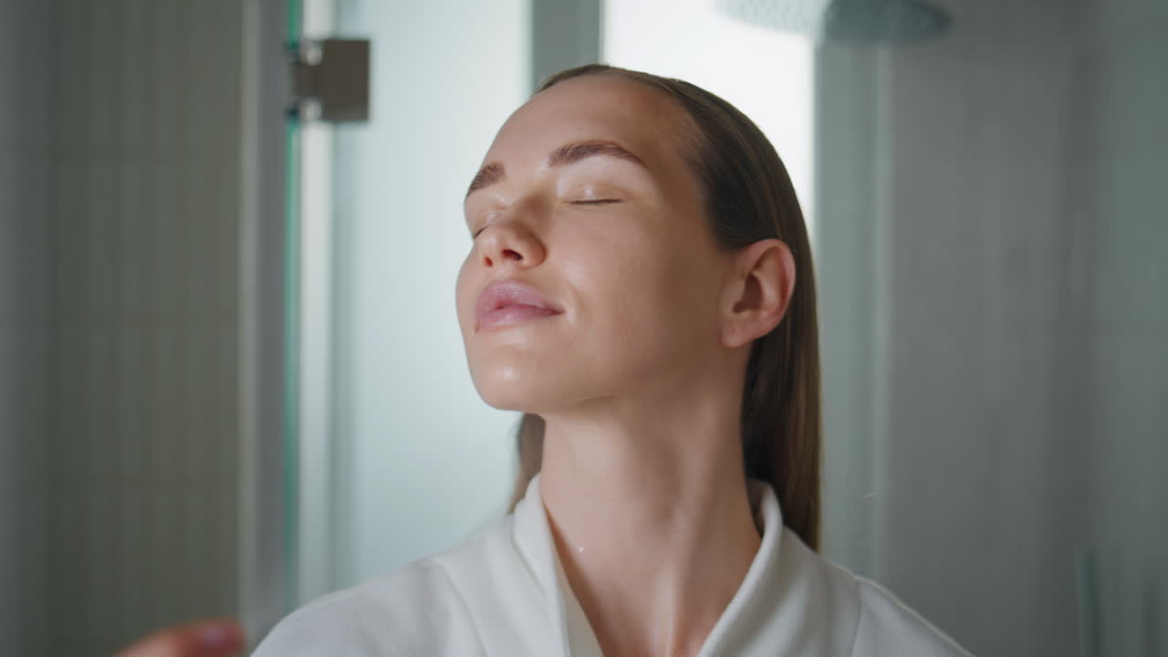 Woman spraying face water in bathroom closeup. Pretty lady using moisturizer