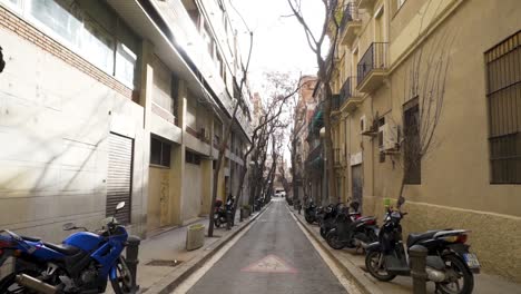 narrow city street with parked motorcycles