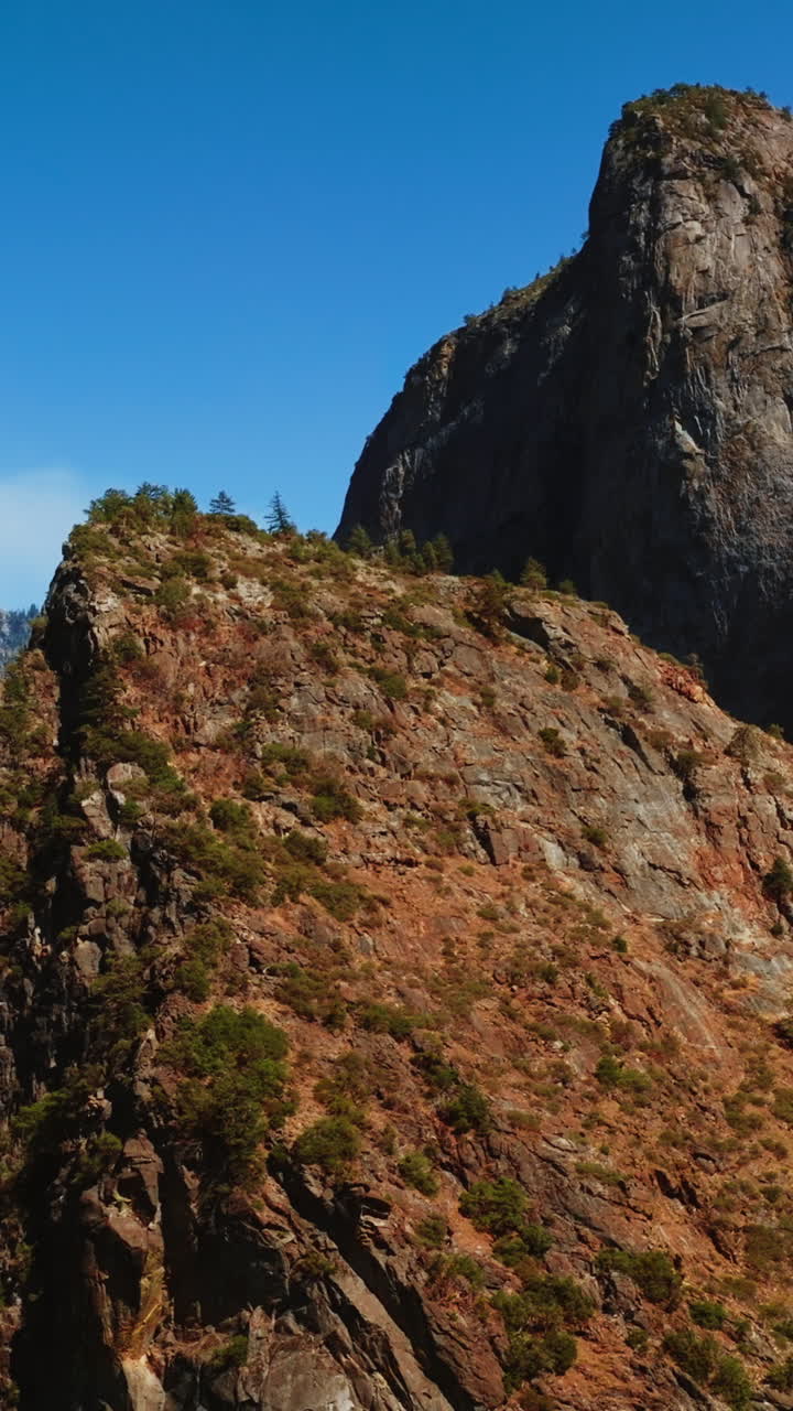 Breath-taking view of mountains in Yosemite National Park, California, USA. Splendid rocks and cliffs at backdrop of blue clear sky. Vertical video