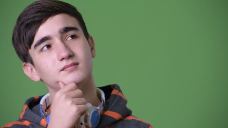 joven y guapo adolescente iraní contra un fondo verde