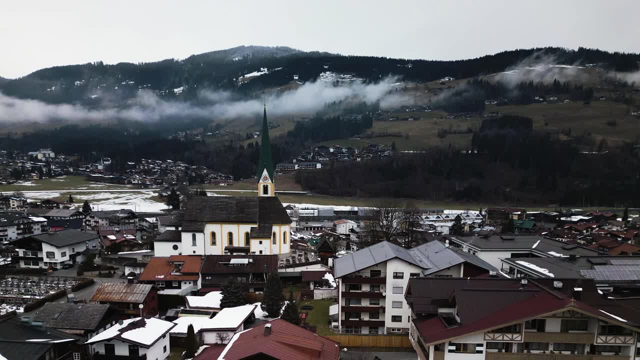 hermosa torre de la iglesia en kirchberg y el paisaje montañoso en el fondo, vista aérea de dron