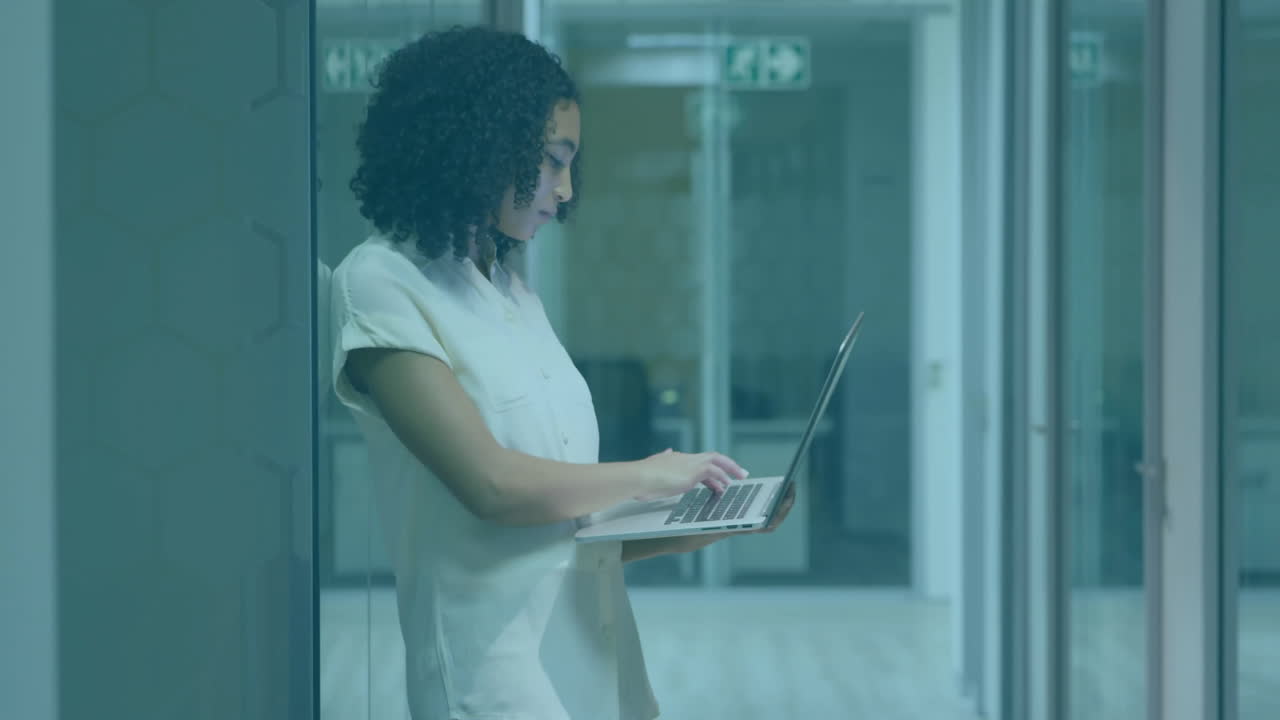 Animazione di elaborazione dati finanziari su una donna d'affari afroamericana che usa un laptop in ufficio.