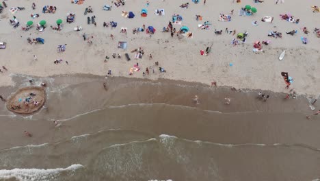 revealing aerial footage of a crowded beach along a north sea city shore of zandoort, netherlands