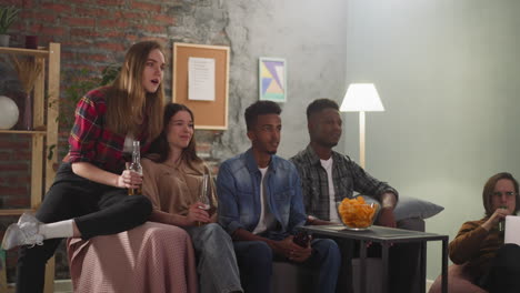 group of emotional friends watches football championship