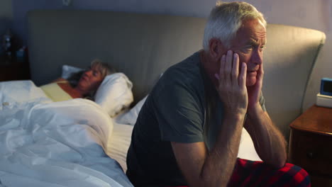 worried senior man in bed at night suffering with insomnia