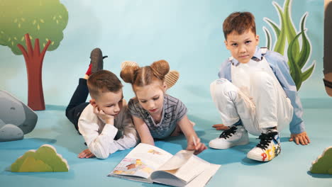 funny children read a book on decorative background. studio shooting of children