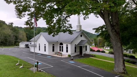 church-aerial-in-zionville-nc,-north-carolina,-zionville-baptist-with-american-flags-in-foreground