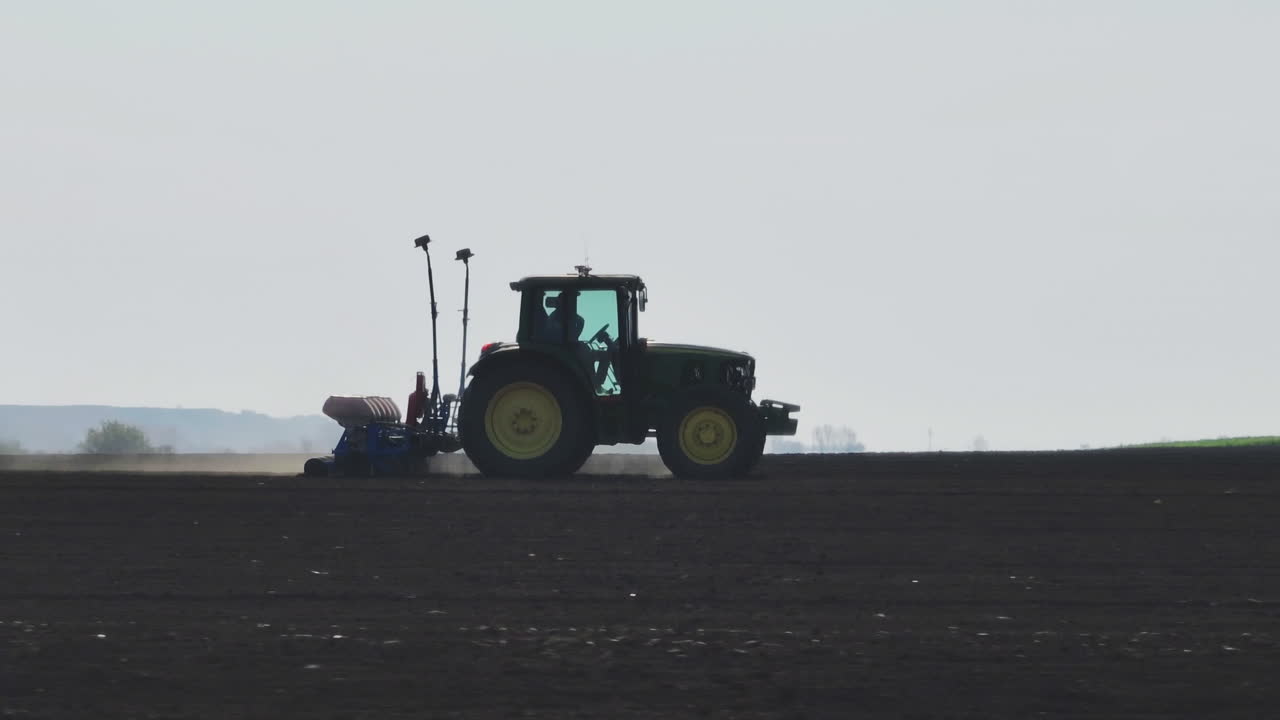 트랙터가 에 씨을 심고 있습니다.