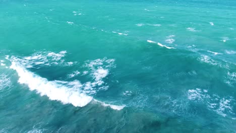 Billowing-waves-in-the-coastal-area-of-Tayrona-National-Natural-Park-the-highest-coastal-mountain-in-the-world,-bathed-in-the-crystal-clear-waters-of-the-Caribbean-sea-in-Colombia