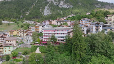 aerial video moving away from a hotel in the town of molveno in northern italy with the dolomite mountains in the background.