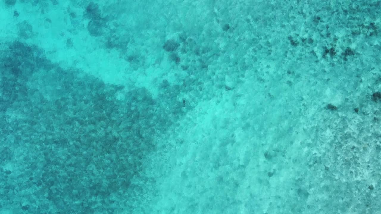 Flyover shallow turquoise lagoon water: A copy space moving background