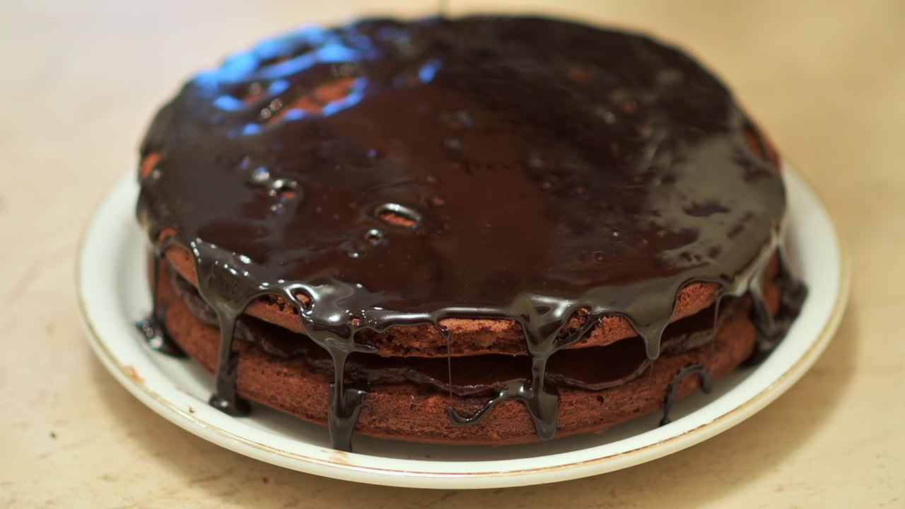 Primer plano de glaseado de chocolate que se vierte sobre un pastel casero
