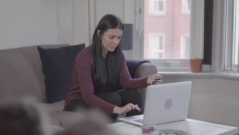 Wide-Shot-of-Young-Attractive-Woman-Using-Laptop-To-Make-Purchases-Online---Ungraded