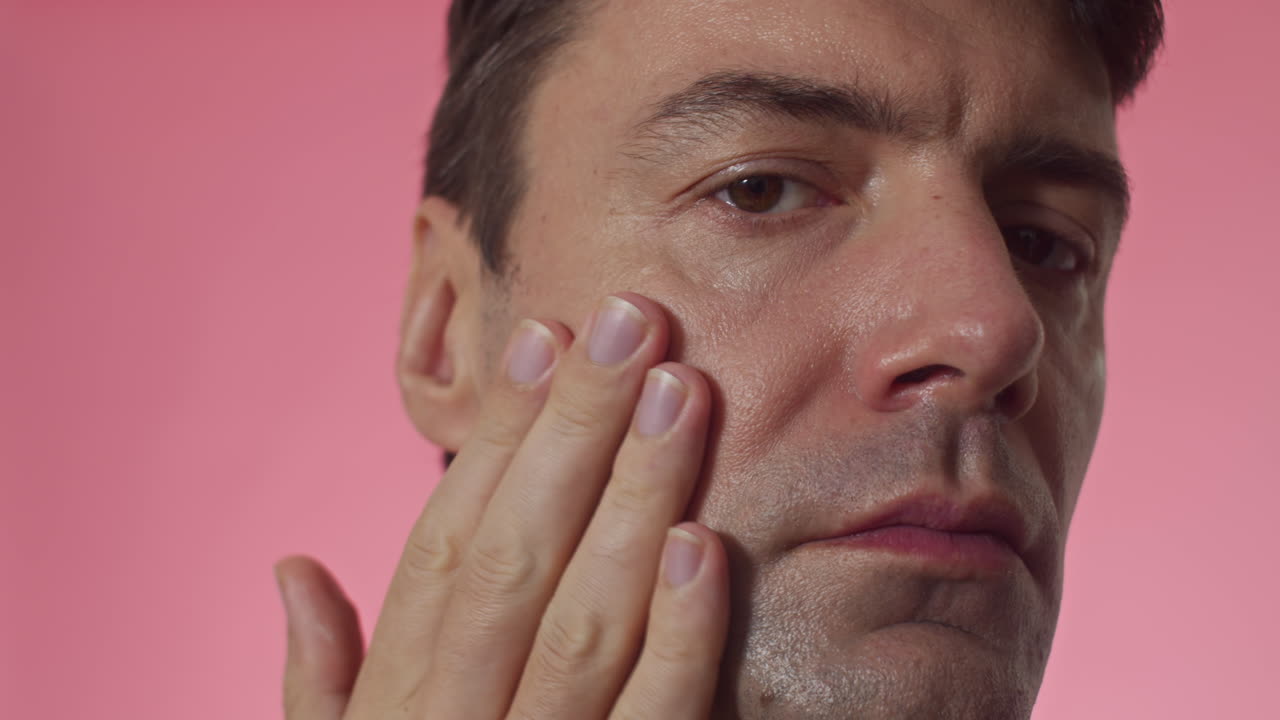 Middle-aged Man Rubbing Nourishing Cream into Skin on Face