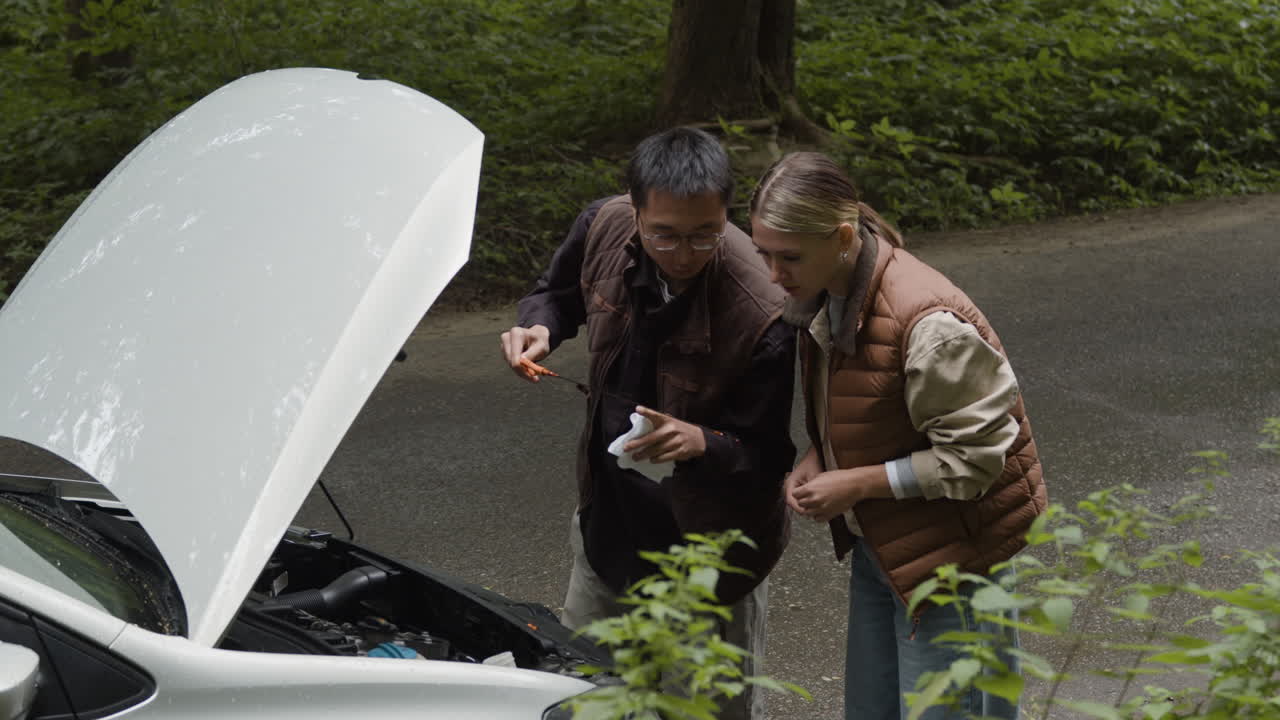 Couple checking car engine