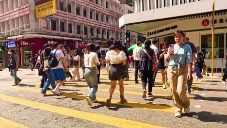 personas cruzando una calle bulliciosa en hong kong