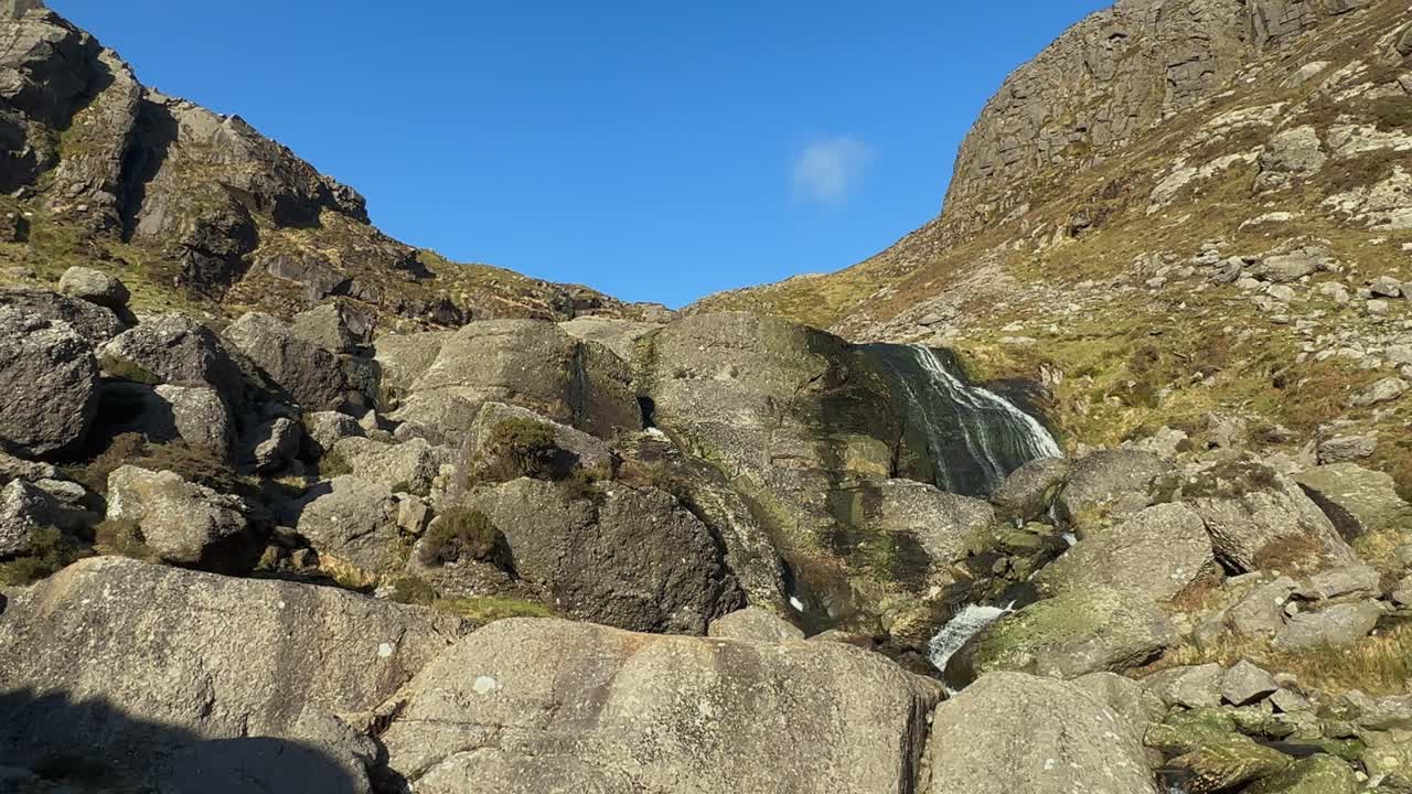 Acqua che scende a rivoli al rallentatore da una cascata a basso flusso nelle montagne Comeragh, Irlanda.