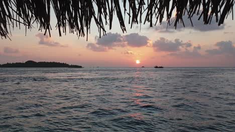 stunning slow motion of romantic sunset and thatched roof in maldives