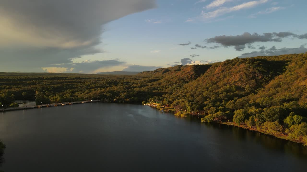 아르헨티나 코르도바 시의 프리메로 강에 건설된 산 로케 댐 위의 초목이 우거진 언덕을 가로지르는 역동적인 황금 시간 공중 촬영