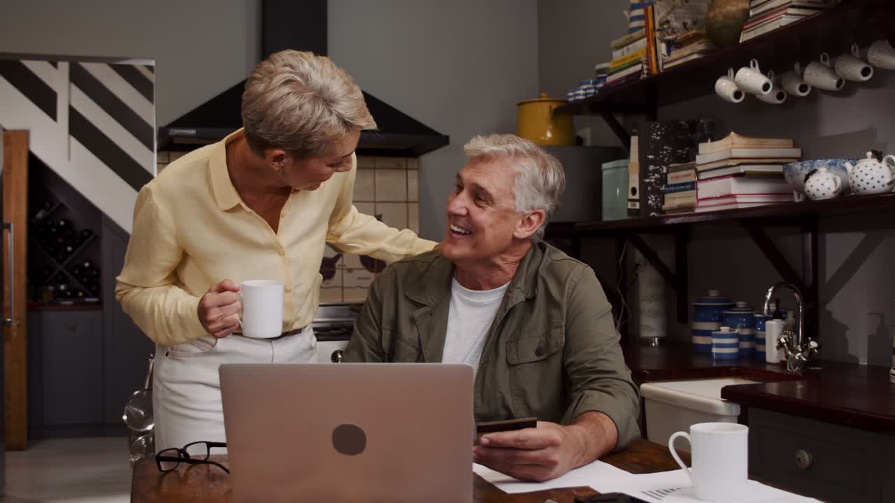 Caucasian mature couple organising finances in kitchen