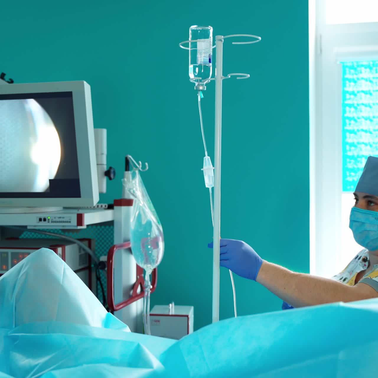 Nurse near dropper in the operating room. Medical assistant on the modern equipment background during surgery in hospital.