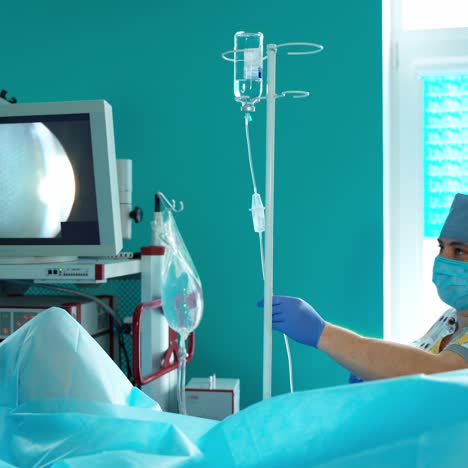 nurse near dropper in the operating room. medical assistant on the modern equipment background during surgery in hospital.