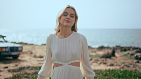 blonde woman in a white dress by the ocean