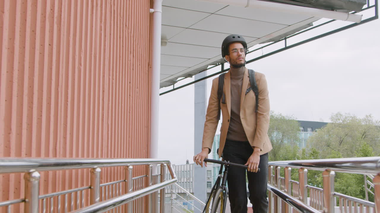 Smiling American Man With Helmet And Backpack Walking To The Office With His Bike And Looking At The Camera