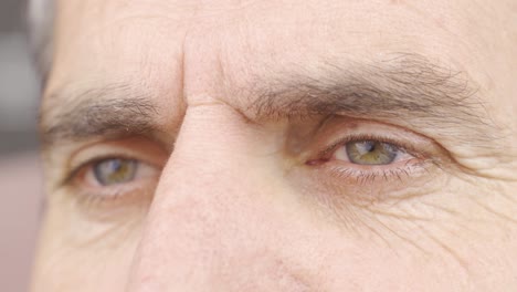 close-up of mature man rubbing his green eyes.