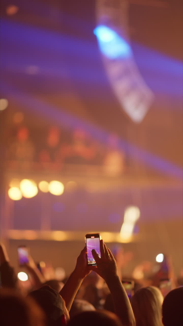 Membro del pubblico che registra un concerto dal vivo con lo smartphone
