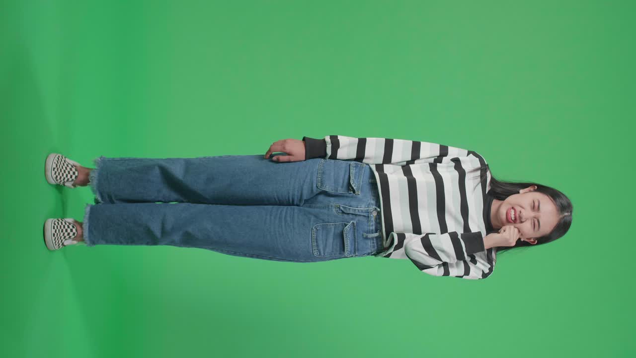 Full Body Of An Asian Woman Having Toothache While Standing In Front Of Green Screen Background