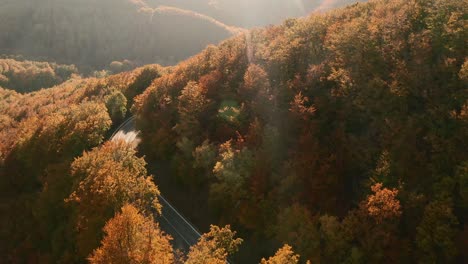 Bellas-Imágenes-Aéreas-De-Un-Camino-Panorámico-Que-Serpentea-En-Un-Bosque-De-Colores-Otoñales