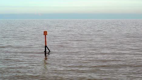 a sea marker post showing the location of the end of a submerged sea groyne in sidmouth, devon, england