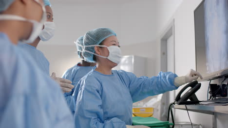 Diverse-female-surgeons-looking-at-x-ray-scans-in-operating-theatre,-slow-motion