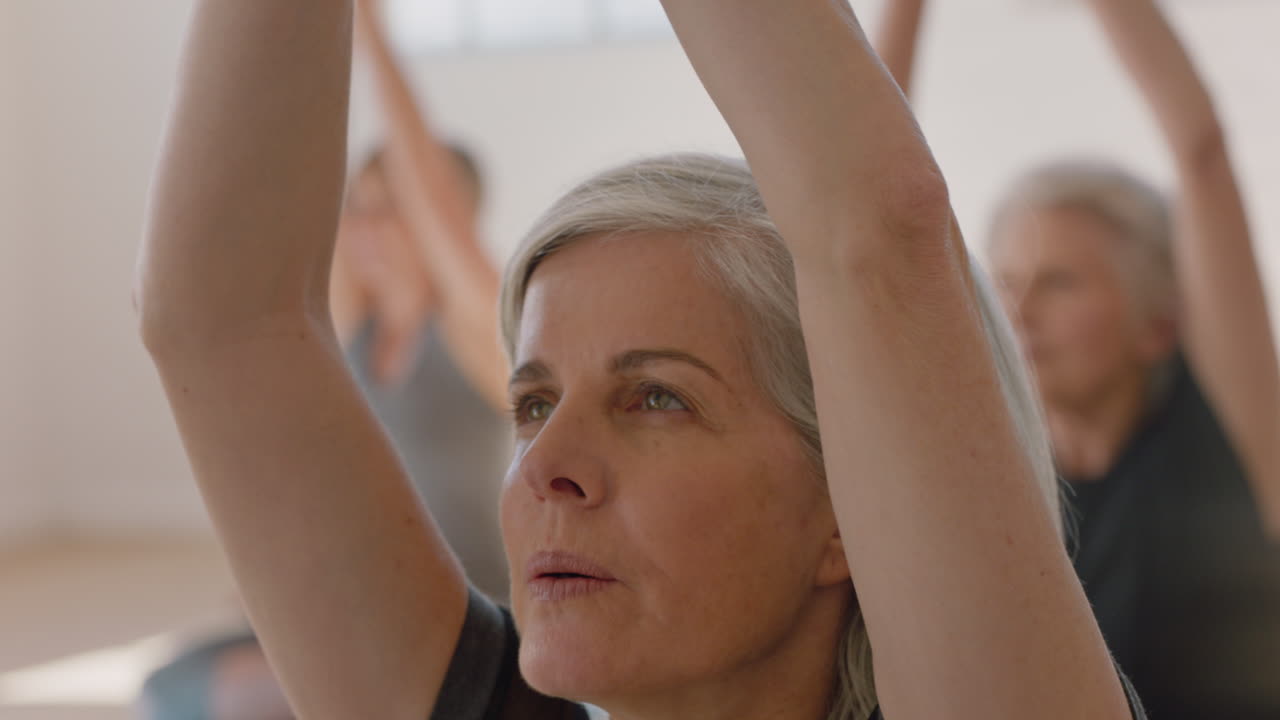 ritratto lezione di yoga bella vecchia donna che esercita una sana meditazione praticando la posa di preghiera godendo di un allenamento di forma fisica di gruppo in studio
