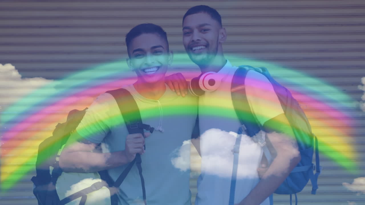 animación de arco iris y nubes sobre una pareja gay sonriente con mochilas abrazadas
