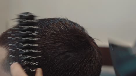 a un joven se le corta el cabello en una barbería en primer plano