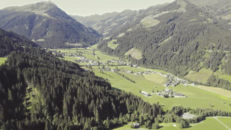 aerial over picturesque tyrolean countryside with forest covered mountains and grassy fields-1