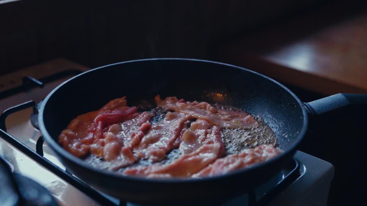 Cooking Bacon On Frying Pan For Breakfast. - closeup shot