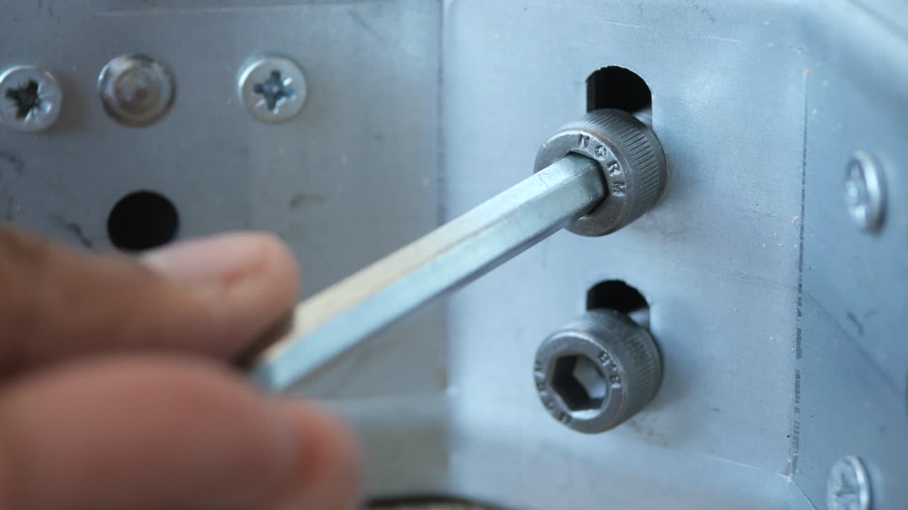 알렌 키로 나사를 단단히 는 손의 가까운 모습.