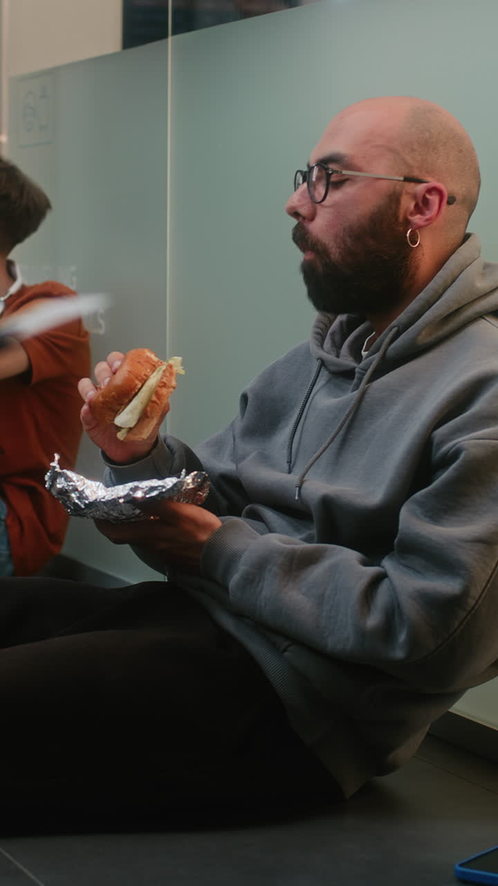 Man Eating a Burger in an Office