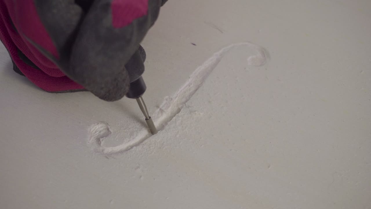 Man work on wood with small rotating rasp from above 4K