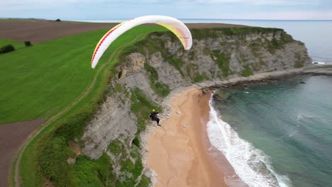 Persona-Volando-En-Parapente-Sobre-Una-Hermosa-Costa-En-España---Vista-Aérea