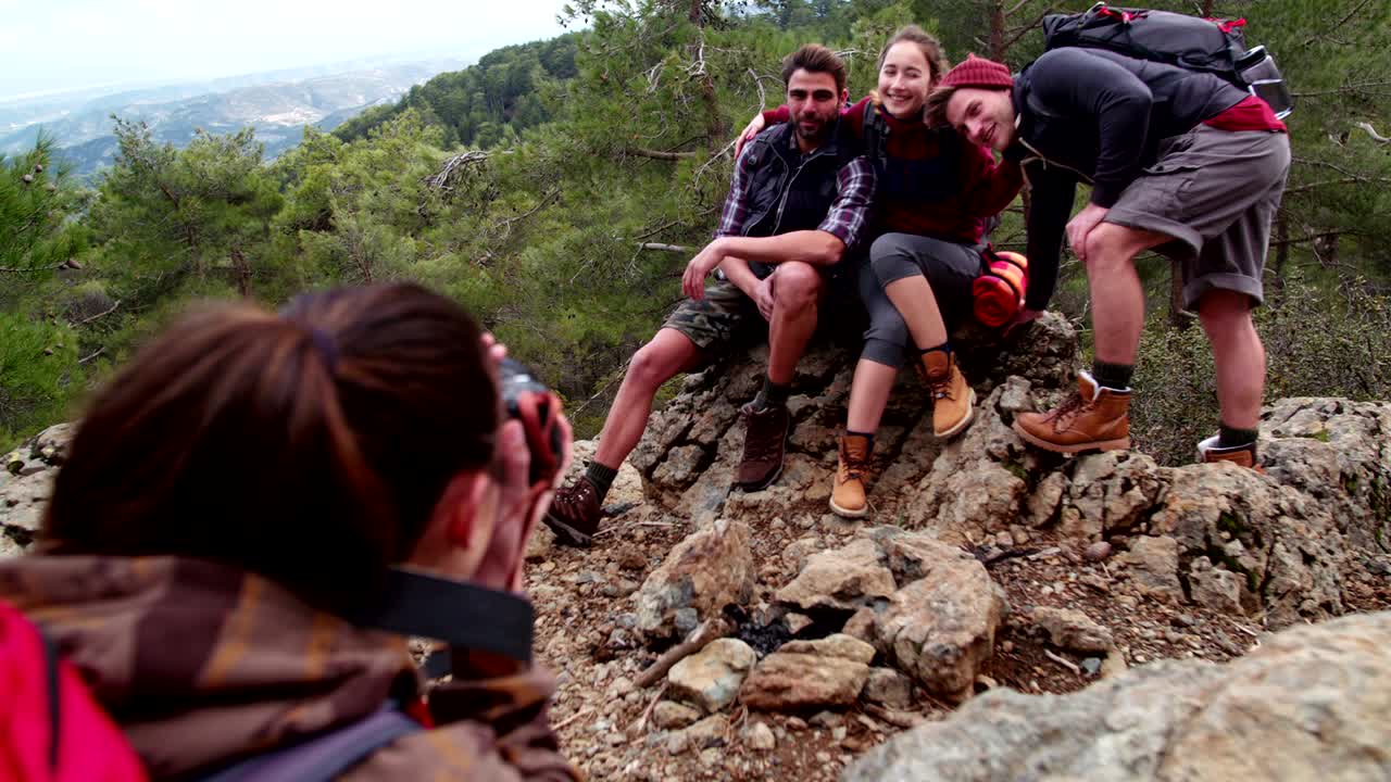 Young hiker friends taking a photo on top of mountain