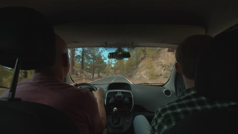 a view of a mountain road from a backseat of a moving car